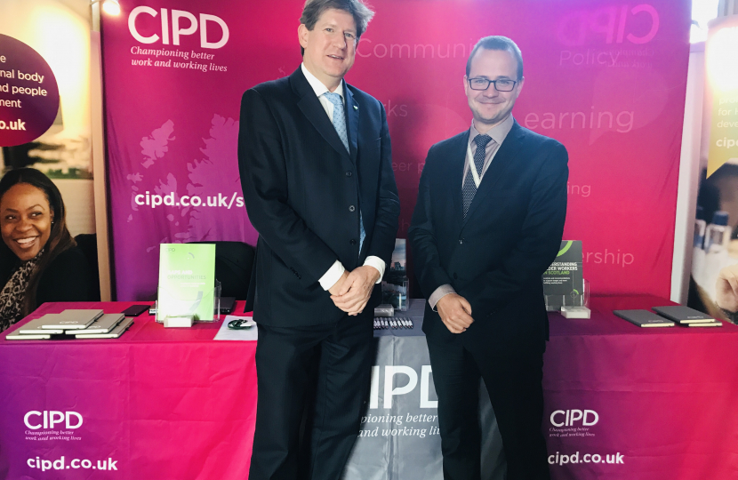 Alex and Marek standing in front of the CIPD booth at Holyrood.