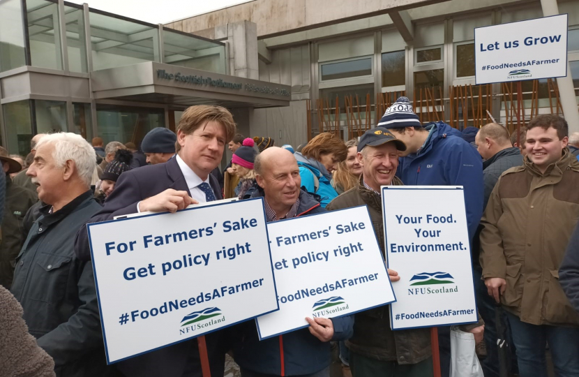 Alex holding a sign at the NFU Scotland rally.