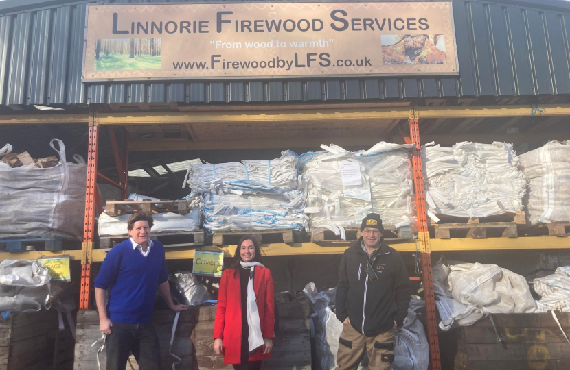 Alex stands in front of Linnorie Firewood Services with two of the Services' team members.